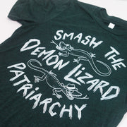 close up angled image of an emerald green tri blend tee shirt on a white background. tee has center chest print in white that says smash the demon lizard patriarchy with two lizards