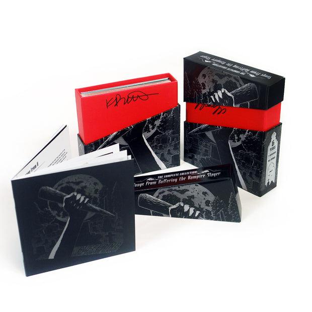 CD box set on white background. image on front of a hand holding a wooden stake with an angled red slash showing where the box top connects. top is lifted to show inside where the Cee dees will be. Also shows autographs of Jenny and Kristen