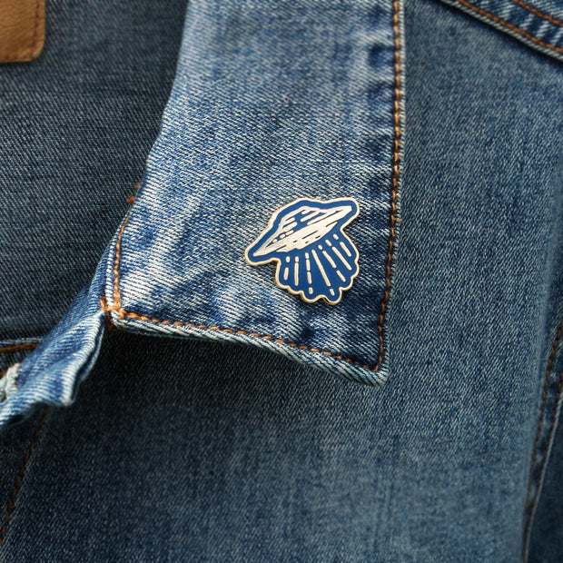 image of a U F O pin on a jean jacket collar
