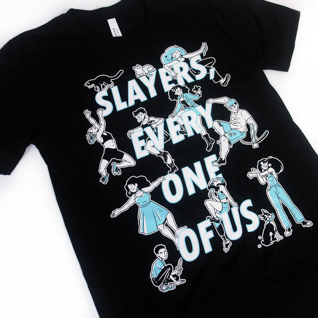 close up, angled image of a black tee shirt on a white background. tee has full body print. there is stacked white text that reads, slayers every one of us, with various characters surrouding the words.