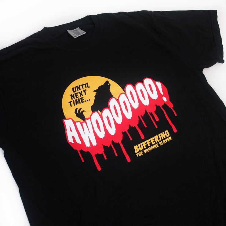 close up, angled image of a black tee shirt on a white background. tee has center chest print in white and red that says AWOOOOOO! Above is an orange moon with a black Silhouette of a warewolf and the words until next time. on the bottom says buffering the vampire slayer.